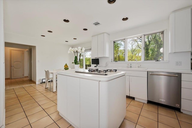 kitchen with a sink, white gas cooktop, stainless steel dishwasher, light countertops, and a kitchen island