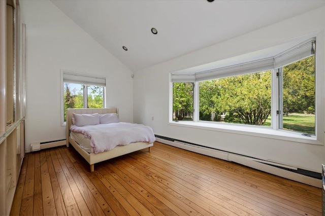 bedroom with vaulted ceiling, a baseboard radiator, and light wood-style floors