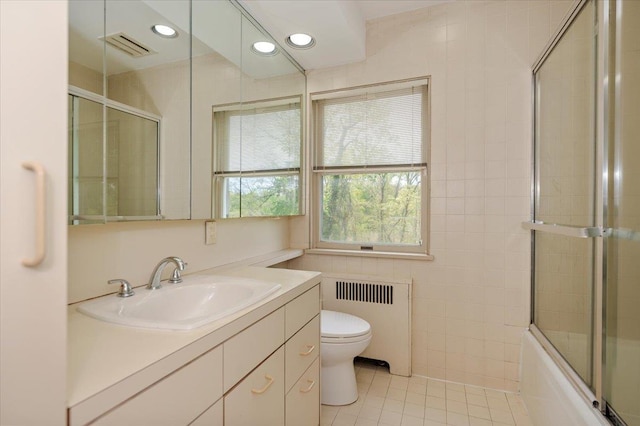 full bath with tile walls, toilet, radiator heating unit, visible vents, and tile patterned flooring