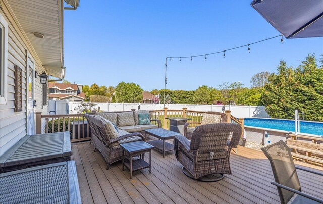 wooden terrace with a fenced backyard, a fenced in pool, and outdoor lounge area