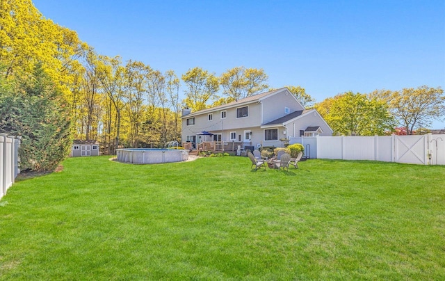 back of house featuring a yard, a fenced backyard, and a fenced in pool