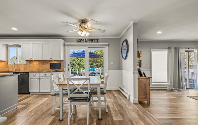 dining room with a baseboard radiator, light wood-style flooring, crown molding, and ceiling fan