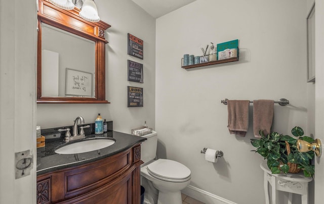 bathroom featuring toilet, baseboards, tile patterned flooring, and vanity