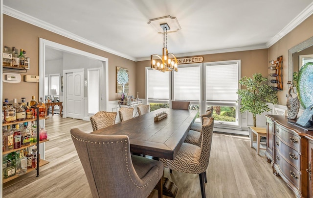 dining area featuring a baseboard heating unit, a healthy amount of sunlight, an inviting chandelier, and crown molding