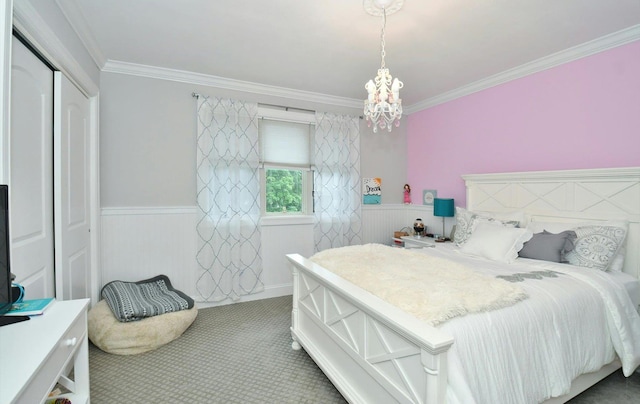 bedroom with a notable chandelier, crown molding, wainscoting, and carpet floors