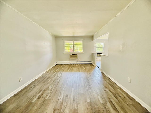 spare room featuring baseboards, a baseboard radiator, wood finished floors, and ornamental molding