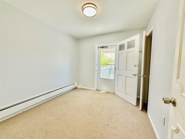 spare room with baseboards, light carpet, and a baseboard heating unit