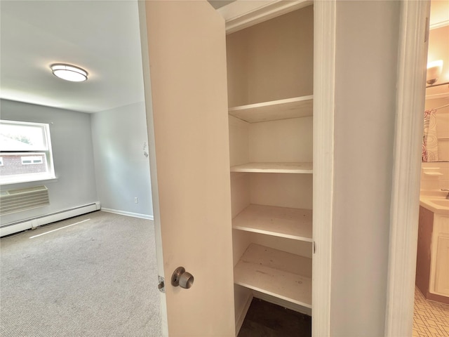 closet with a baseboard heating unit and a wall mounted AC