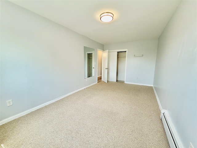 unfurnished bedroom with a closet, baseboards, light colored carpet, and a baseboard radiator