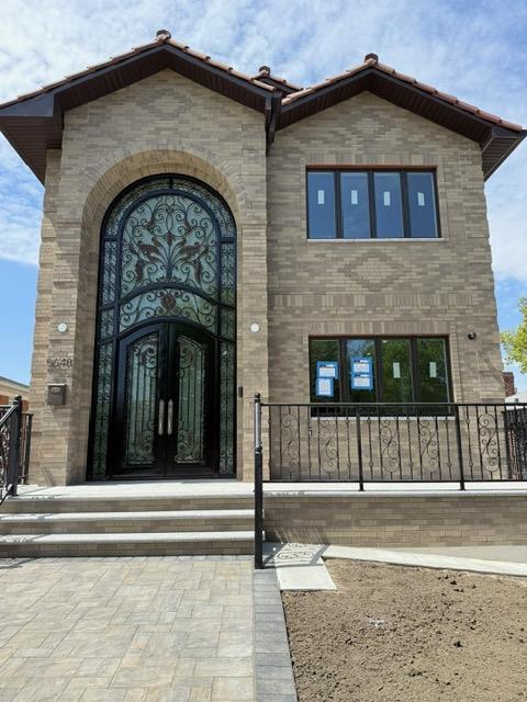 view of exterior entry with french doors and brick siding