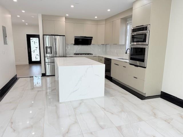 kitchen with a center island, modern cabinets, gas stovetop, stainless steel fridge, and black dishwasher