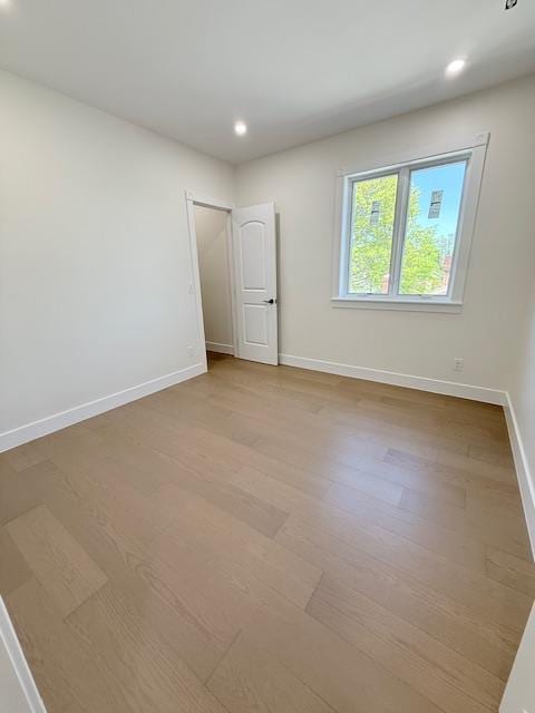 empty room with baseboards, recessed lighting, and wood finished floors
