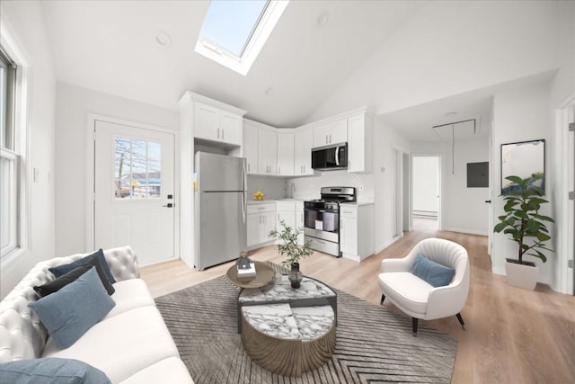 living room featuring light wood-style flooring, a skylight, electric panel, and high vaulted ceiling