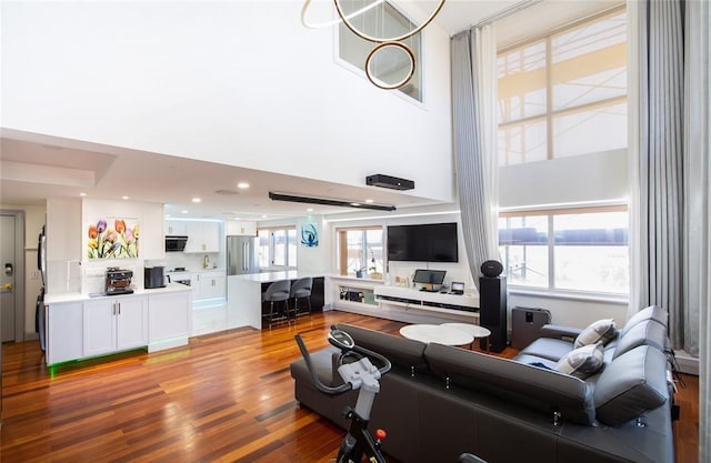 living area featuring light wood-style flooring and a towering ceiling