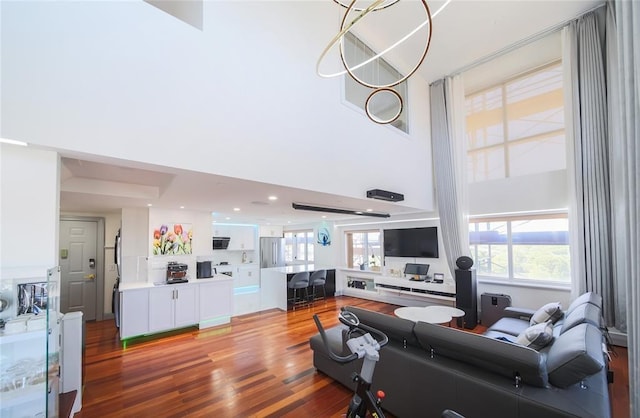 living room featuring a towering ceiling and light wood-type flooring