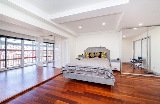 bedroom with recessed lighting, access to exterior, and wood finished floors