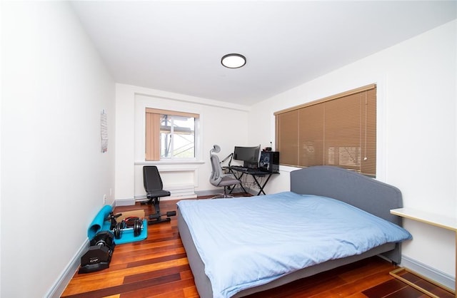 bedroom with baseboards and wood finished floors