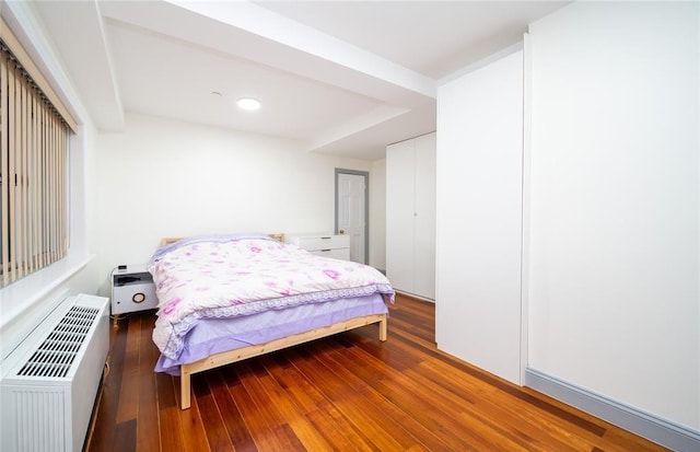 bedroom featuring wood-type flooring, an AC wall unit, and recessed lighting