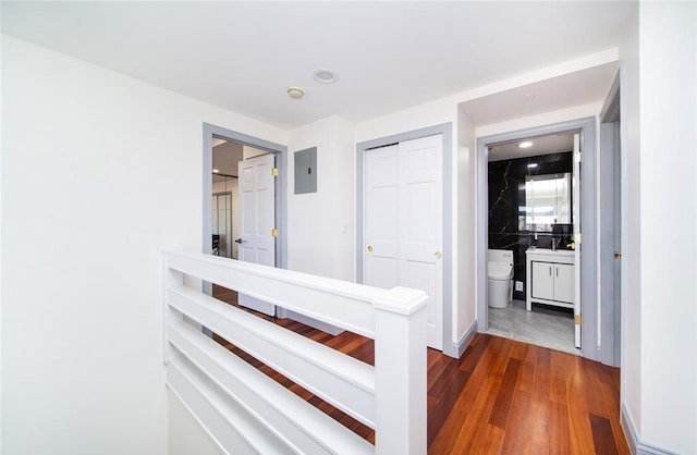hallway featuring recessed lighting, electric panel, and dark wood finished floors