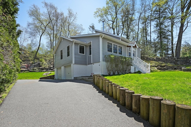 view of front of house featuring a garage, driveway, and a front yard