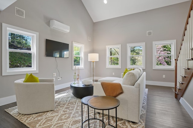 living room featuring stairs, wood finished floors, baseboards, high vaulted ceiling, and a wall unit AC
