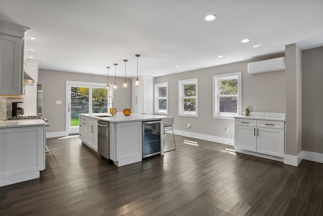 kitchen with beverage cooler, baseboards, a wall unit AC, a sink, and dishwasher