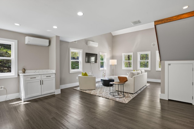 living area featuring baseboards, plenty of natural light, a wall mounted AC, and dark wood-type flooring