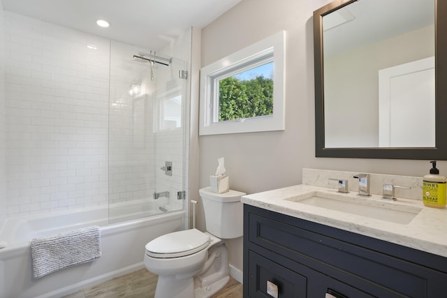 full bath featuring vanity, wood finished floors, bathing tub / shower combination, toilet, and baseboards