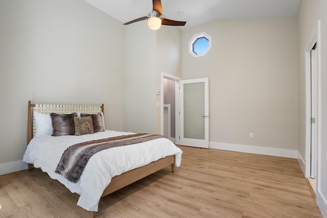 bedroom featuring high vaulted ceiling, baseboards, light wood-type flooring, and ceiling fan