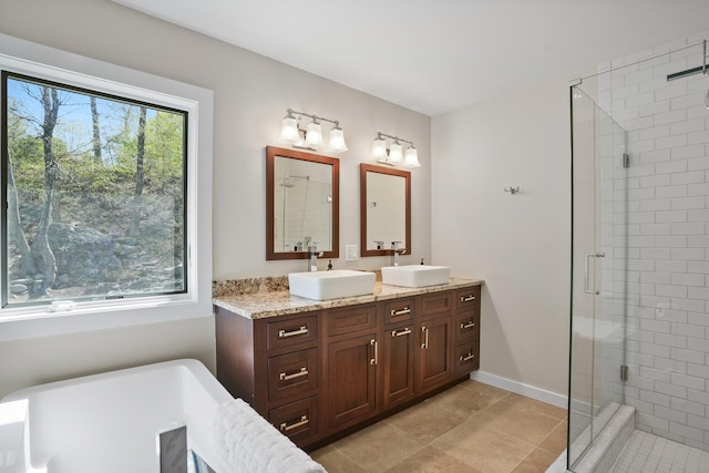 bathroom featuring double vanity, a sink, and a stall shower