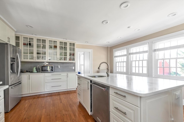 kitchen with white cabinetry, appliances with stainless steel finishes, decorative backsplash, and a sink