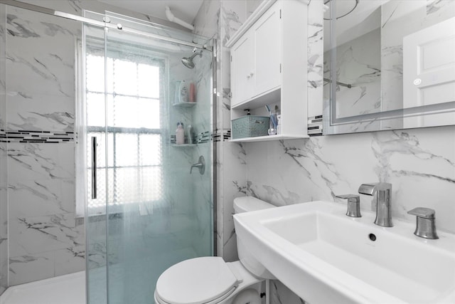 bathroom with a sink, a marble finish shower, and toilet