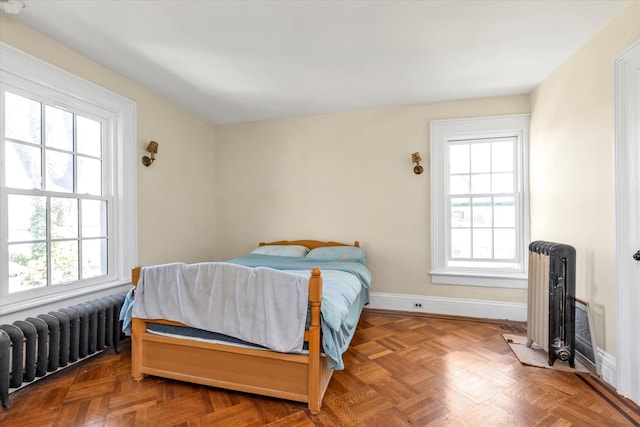 bedroom featuring baseboards and radiator