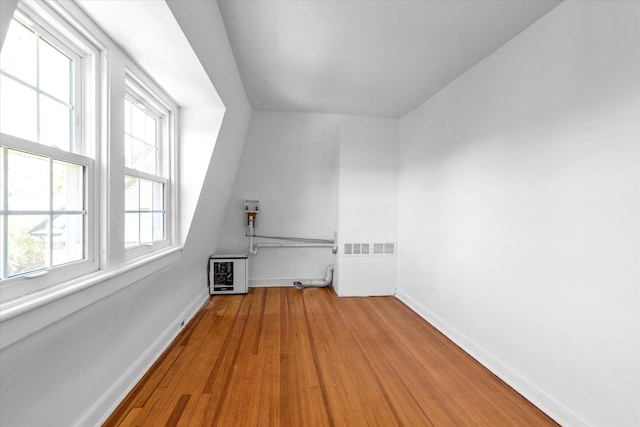 bonus room with baseboards and wood finished floors