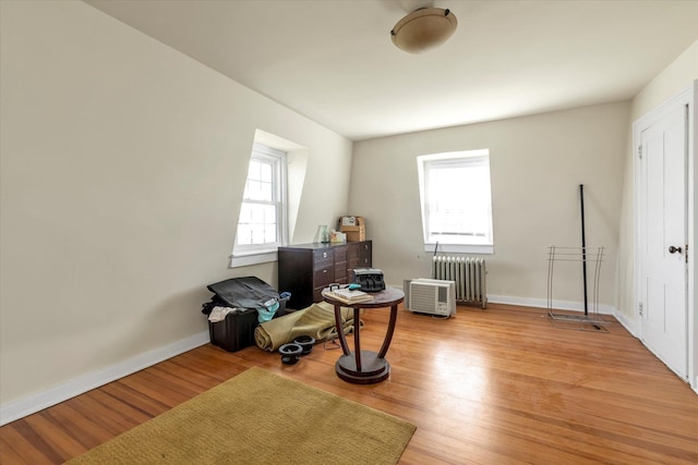 misc room featuring radiator, baseboards, and light wood-style flooring