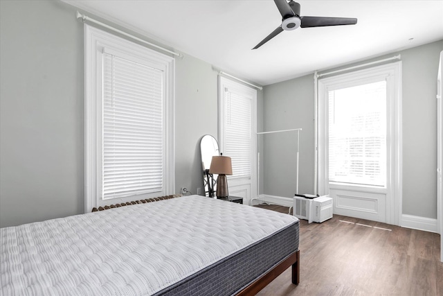 bedroom with baseboards, a ceiling fan, and wood finished floors