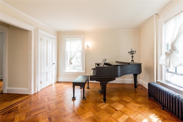 sitting room with radiator heating unit, baseboards, plenty of natural light, and crown molding