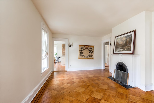 unfurnished living room with baseboards and a fireplace with flush hearth
