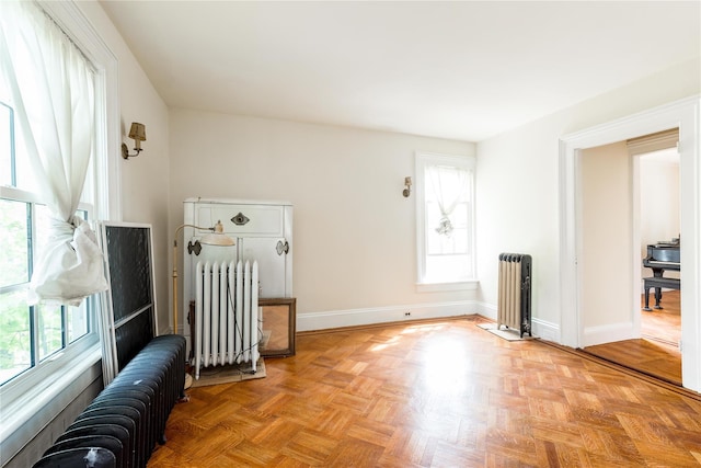 unfurnished room with baseboards and radiator heating unit