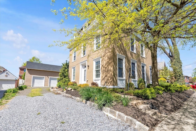 view of front of house featuring a detached garage and an outbuilding