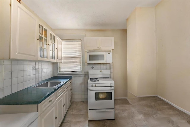 515 S 9th Ave, Mount Vernon, NY 10550 - kitchen featuring dark countertops, white appliances, glass insert cabinets, white cabinetry, and a sink