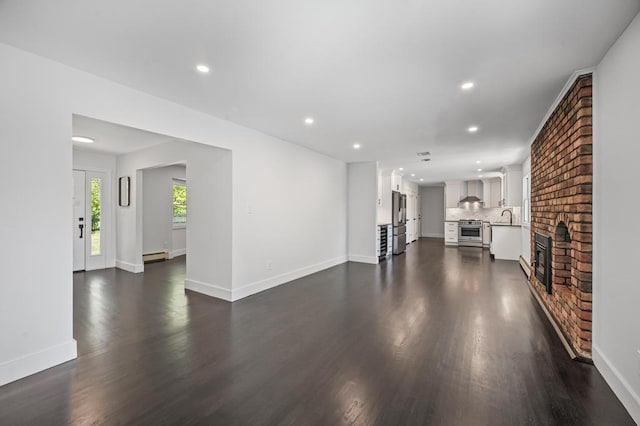 unfurnished living room featuring recessed lighting, baseboards, a baseboard heating unit, and dark wood-type flooring