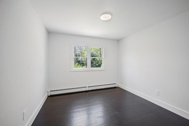 empty room with baseboards, dark wood-style floors, and baseboard heating