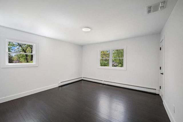 unfurnished room with a baseboard radiator, baseboard heating, dark wood-style floors, and visible vents