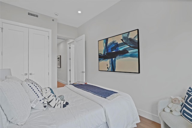 bedroom with visible vents, wood finished floors, baseboards, a closet, and recessed lighting