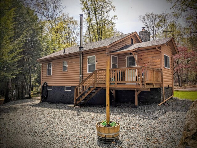 25 E Reindeer Trl, Bethel, NY 12778 - rear view of house featuring log veneer siding, a chimney, roof with shingles, a deck, and stairway