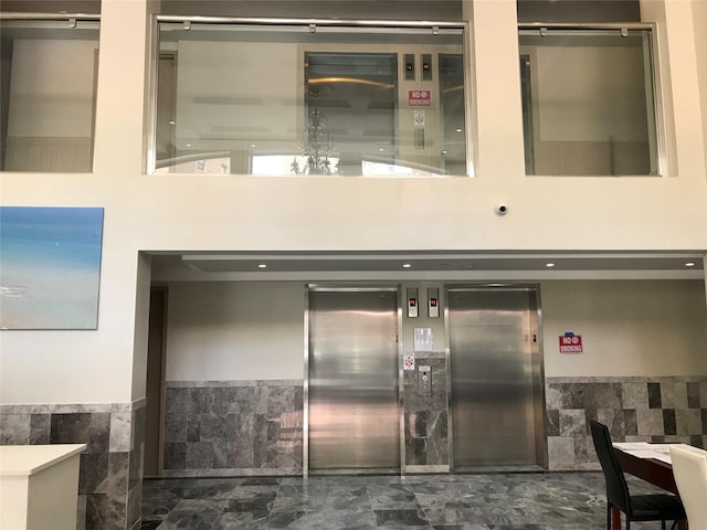 65-38 Austin St Unit 3B, Rego Park, NY 11374 - building lobby featuring a high ceiling, wainscoting, and tile walls