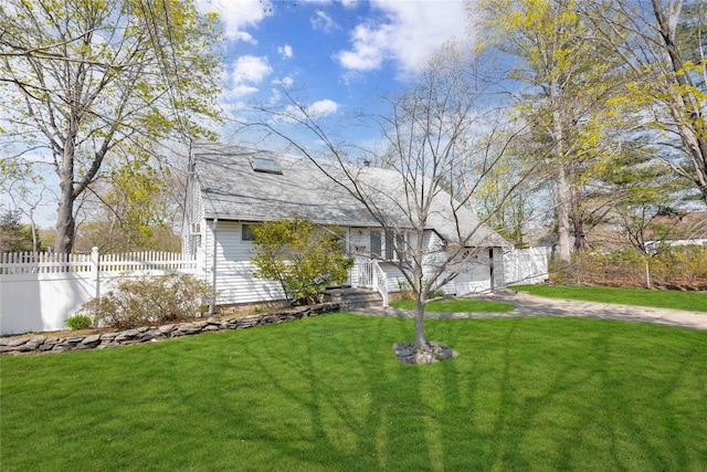 view of front of home featuring fence, driveway, and a front yard