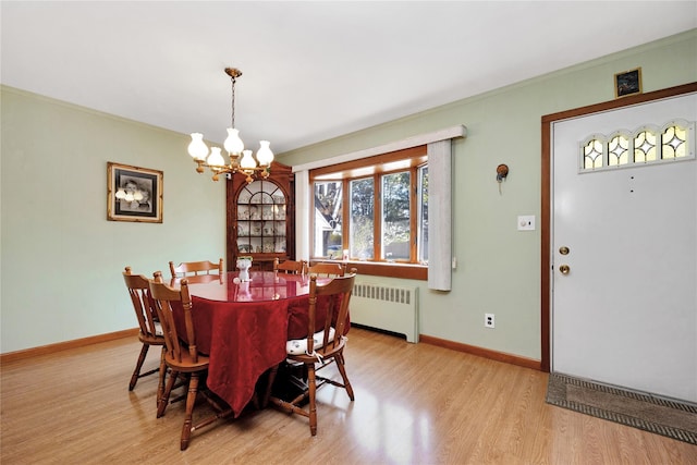 dining room featuring crown molding, a chandelier, radiator heating unit, baseboards, and light wood-type flooring