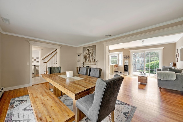 dining space featuring light wood finished floors, stairway, visible vents, and ornamental molding